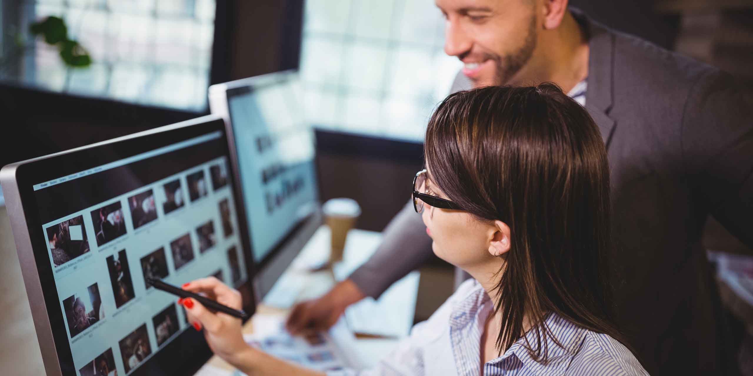 Marketing team reviewing campaign designs on computer screens